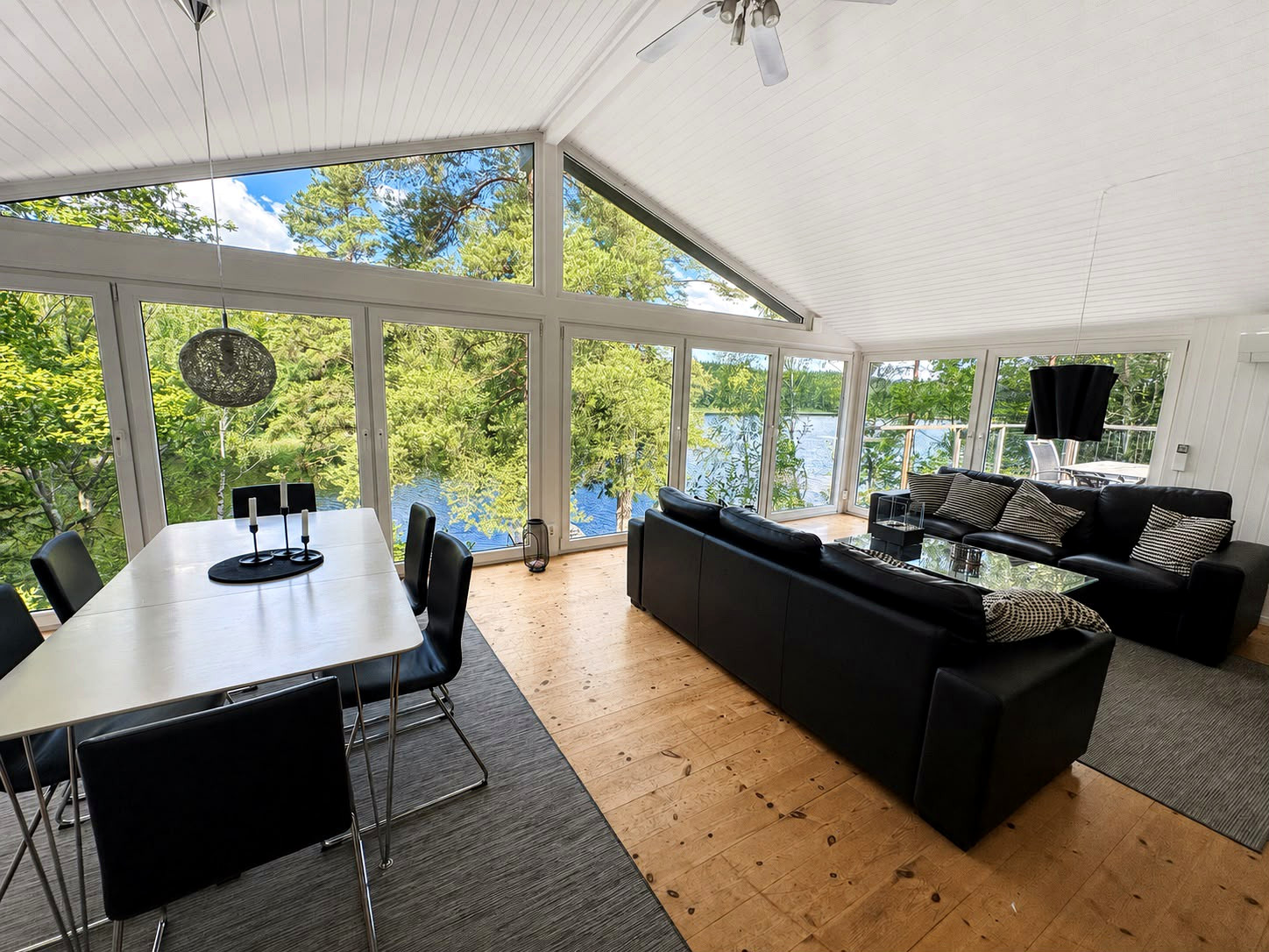 Interior of a holiday home with a view through panoramic windows across the lake